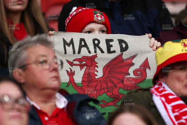 140426 - Wales v Albania - 2027 FIFA Women's World Cup Qualifying - A fan of Wales holds up a sign that reads ‘Mared’ in support prior to the game