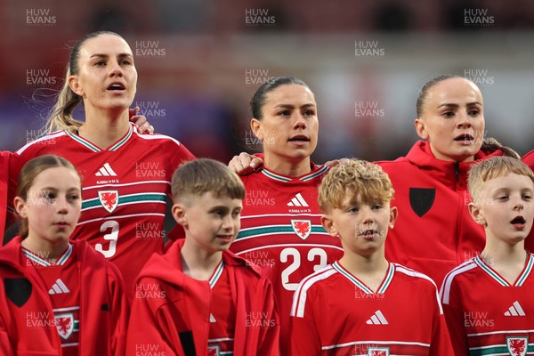 140426 - Wales v Albania - 2027 FIFA Women's World Cup Qualifying - Gemma Evans, Ffion Morgan and Lily Woodham of Wales sing the national anthem