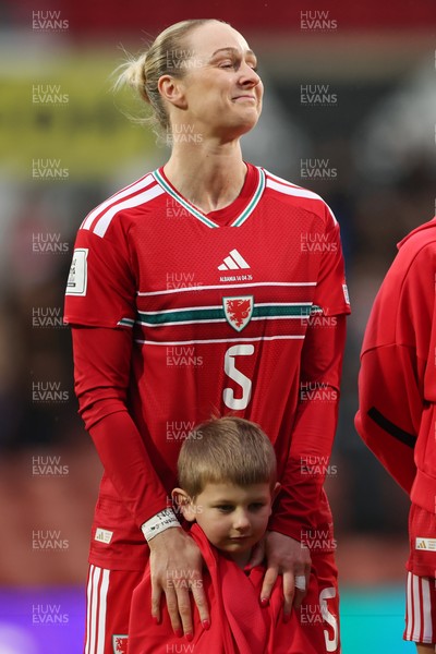 140426 - Wales v Albania - 2027 FIFA Women's World Cup Qualifying - Rhiannon Roberts of Wales reacts after giving a mascot her jacket