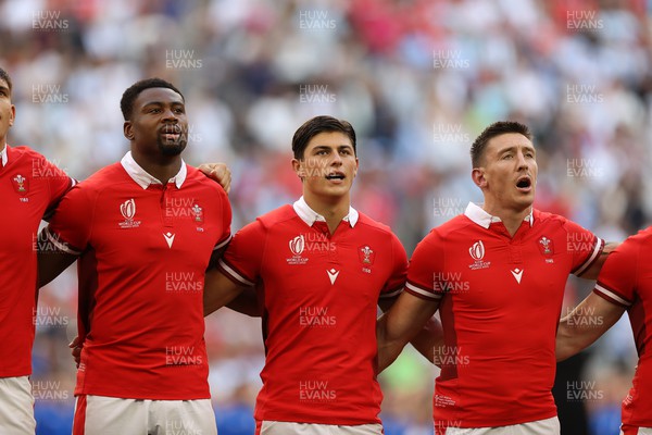 141023 - Wales v Argentina - Rugby World Cup Quarter Final - Christ Tshiunza, Louis Rees-Zammit and Josh Adams of Wales sing the anthem