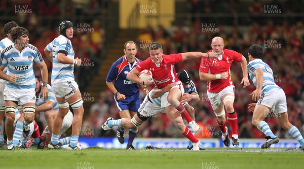 20.08.11 Wales v Argentina. Wales' Tavis Knoyle is tackled by Argentina's Julio Farias Cabello. 