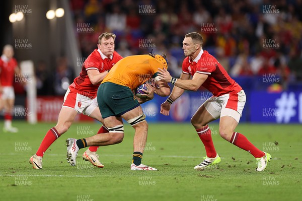 240923 - Wales v Australia - Rugby World Cup France 2023 - Pool C - Tom Hooper of Australia is tackled by Nick Tompkins and George North of Wales 