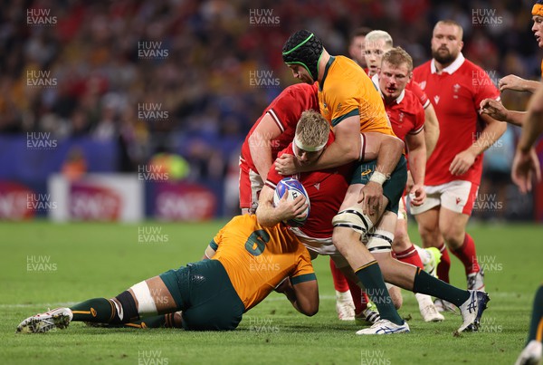 240923 - Wales v Australia - Rugby World Cup France 2023 - Pool C - Aaron Wainwright of Wales is tackled by Rob Leota and Nick Frost of Australia 