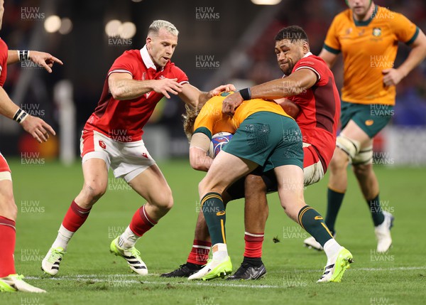 240923 - Wales v Australia - Rugby World Cup France 2023 - Pool C - Carter Gordon of Australia is tackled by Gareth Davies and Taulupe Faletau of Wales 