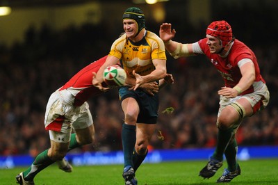 28.11.09 - Invesco Perpetual International Rugby, Wales v Australia Australia's Matt Giteau  passes as Wales' Andrew Bishop and Alun Wyn Jones tackle 