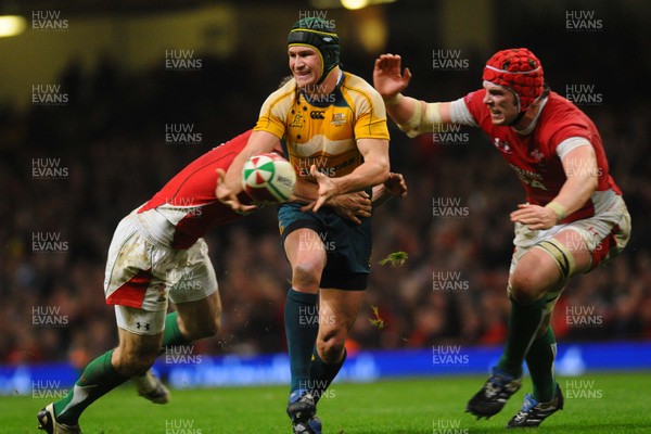 28.11.09 - Invesco Perpetual International Rugby, Wales v Australia Australia's Matt Giteau  passes as Wales' Andrew Bishop and Alun Wyn Jones tackle 