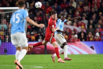 131025 - Wales v Belgium - 2026 FIFA World Cup Qualifying - Ben Davies of Wales is challenged by Jeremy Doku of Belgium