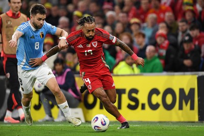 131025 - Wales v Belgium - 2026 FIFA World Cup Qualifying - Sorba Thomas of Wales is challenged by Nicolas Raskin of Belgium