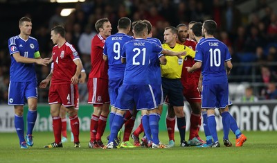 101014 - Wales v Bosnia-Herzegovina, UEFA European Championship 2016 - Referee tries to separate players as dis-agreement escalates