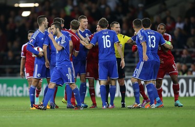101014 - Wales v Bosnia-Herzegovina, UEFA European Championship 2016 - Referee tries to separate players as dis-agreement escalates