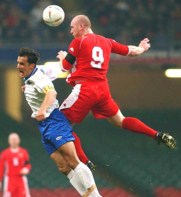 120203 - Wales v Bosnia-Herzegovina - International friendly - Wales' John Hartson takes a high ball from Mirsad Hibic