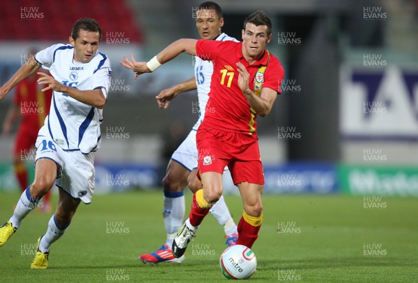 150812 - Wales v Bosnia Herzegovina, Vauxhall International Friendly - Wales' Gareth Bale gets past Bosnia Herzegovina's Senad Lulic and Sejad Salihovic 