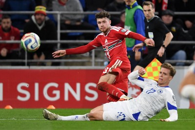 260326 - Wales v Bosnia-Herzegovina - 2026 FIFA World Cup Qualifying - Play-off Semi-final - Neco Williams of Wales is challenged by Dzenis Burnic of Bosnia