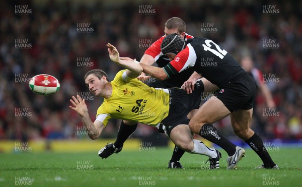 14.11.08 ... Wales v Canada, Invesco Perpetual International 2008 Wales' Andrew Bishop feeds the ball out as Canada's Ryan Smith tackles  