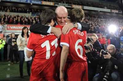 290212 - Wales v Costa Rica -Gary Speed's father Roger hugs his grandsons Ed and Tommy before kick off