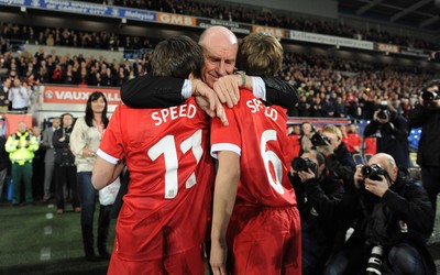 290212 - Wales v Costa Rica -Gary Speed's father Roger hugs his grandsons Ed and Tommy before kick off