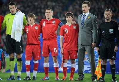 290212 - Wales v Costa Rica -Gary Speed's sons Ed and Tommy sing the national anthem with Wales with captain Craig Bellamy and Aaron Ramsey