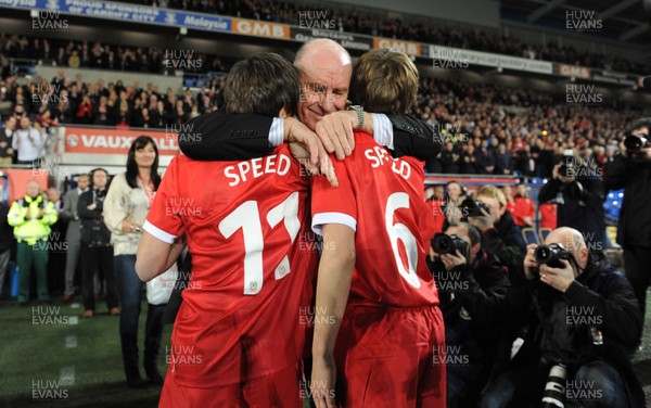 290212 - Wales v Costa Rica -Gary Speed's father Roger hugs his grandsons Ed and Tommy before kick off