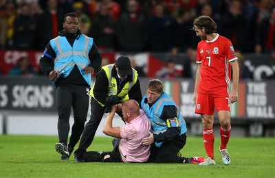 131019 - Wales v Croatia - European Championship Qualifiers - Group E - A pitch invader is wrestled with by stadium staff