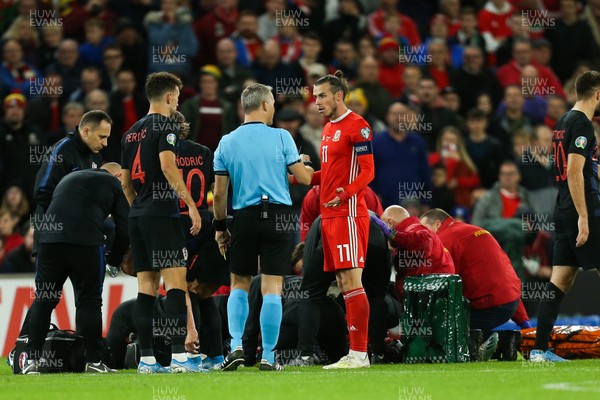 131019 - Wales v Croatia, UEFA Euro 2020 Qualifier - Gareth Bale of Wales speaks to referee as Daniel James of Wales receives treatment after a heavy challenge