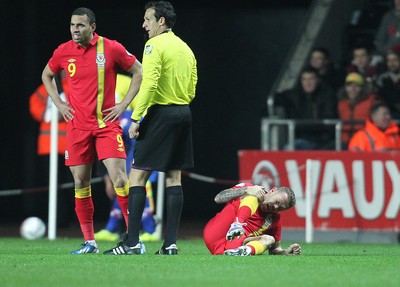 260313 - Wales v Croatia, World Cup Qualifier, Swansea - Wales' Craig Bellamy goes down in the second half of the game holding his right knee
