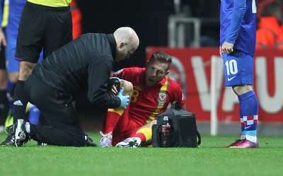 260313 - Wales v Croatia, World Cup Qualifier, Swansea - Wales' Craig Bellamy goes down in the second half of the game holding his right knee