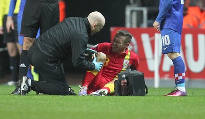 260313 - Wales v Croatia, World Cup Qualifier, Swansea - Wales' Craig Bellamy goes down in the second half of the game holding his right knee