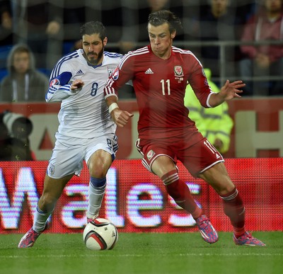 131014 - Wales v Cyprus - UEFA European Championship - Gareth Bale of Wales is tackled by Charis Kyriakou of Cyprus 