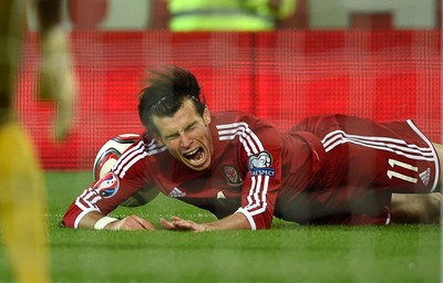 131014 - Wales v Cyprus - UEFA European Championship - Gareth Bale of Wales is tackled by Charis Kyriakou of Cyprus 
