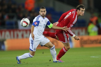 131014 - Wales v Cyprus, UEFA European Championship Qualifier - Wales' Gareth Bale plays the ball past Constantinos Makridis of Cyprus