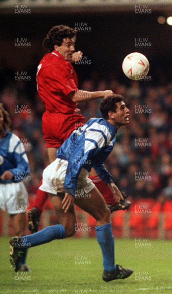 131093 - Wales v Cyprus - FIFA World Cup Qualifier - Dean Saunders of Wales heads the ball above Demetris Iannou of Cyprus