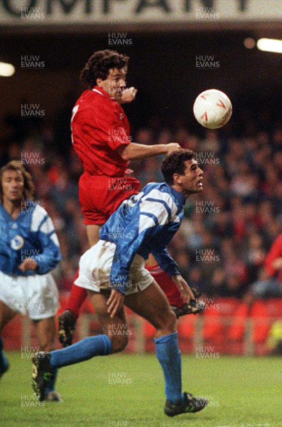 131093 - Wales v Cyprus - FIFA World Cup Qualifier - Dean Saunders of Wales heads the ball above Demetris Iannou of Cyprus