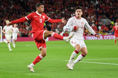 041026 - Wales v Denmark - UEFA Nations League -  Brennan Johnson of Wales is challenged by Joakim Maehle of Denmark