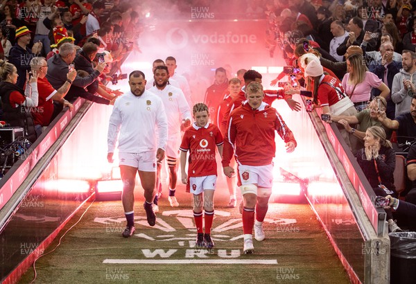 050823 - Wales v England - Vodafone Summer Series - Captains Ellis Genge and Jac Morgan of Wales lead the team out with the mascot