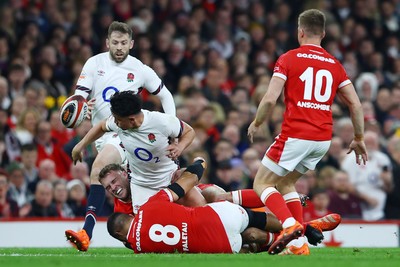 150325 - Wales v England - Guinness Six Nations - Marcus Smith of England offloads as he is tackled by Taulupe Faletau of Wales