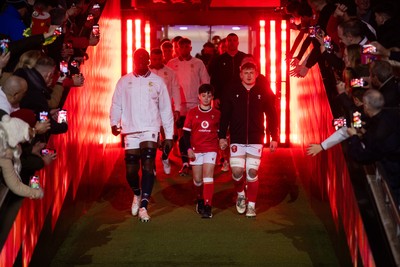 150325 - Wales v England - Guinness Six Nations Championship - Maro Itoje of England and Jac Morgan of Wales walk out into the field with the mascot