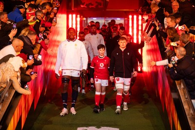 150325 - Wales v England - Guinness Six Nations Championship - Maro Itoje of England and Jac Morgan of Wales walk out into the field with the mascot