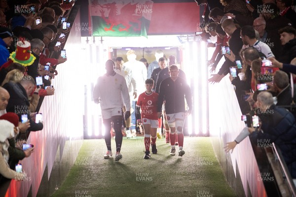 150325 - Wales v England - Guinness Six Nations Championship - Maro Itoje of England and Jac Morgan of Wales walk out into the field with the mascot