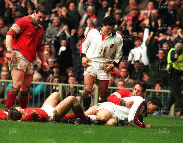 180295 - Wales v England - Five Nations - Rory Underwood of England scores a try despite the tackle of Mark Taylor Brother Tony Underwood celebrates