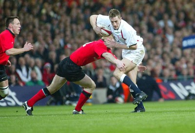 220203 - Wales v England - Six Nations Championship - England's Will Greenwood is tackled by Tom Shanklin