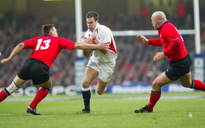 220203 - Wales v England - Six Nations Championship - England's Charlie Hodgson breaks inside Mark Taylor as Ben Evans closes in