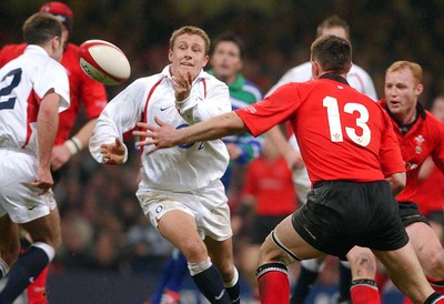 220203 - Wales v England - Six Nations Championship - Jonny Wilkinson passes as Mark Taylor closes in