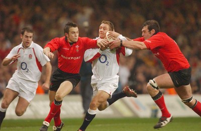 220203 - Wales v England - Six Nations Championship - England's Jonny Wilkinson is tackled by Rhys Williams and Robert Sidoli