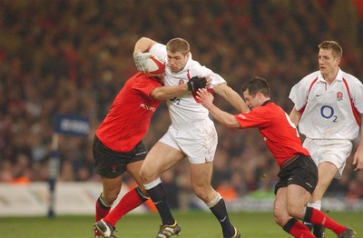 220203 - Wales v England - Six Nations Championship - England's Ben Cohen is tackled by Gavin Thomas and Gareth Cooper