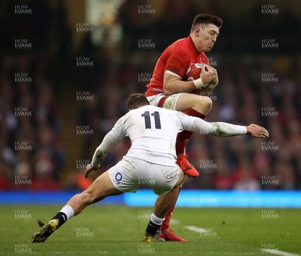 230219 - Wales v England - Guinness 6 Nations Championship - Josh Adams of Wales is tackled by Jonny May of England