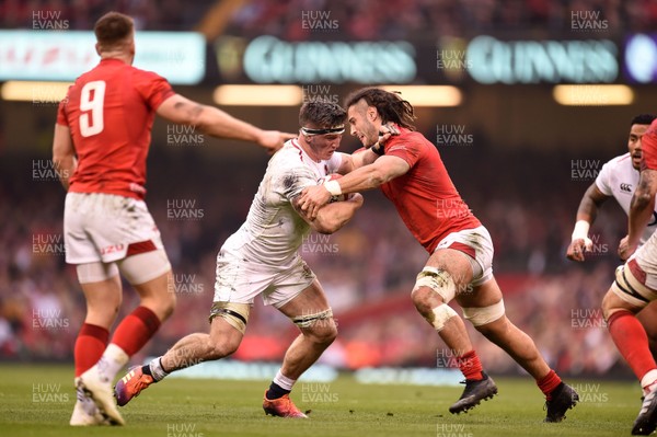 230219 - Wales v England - Guinness Six Nations - Tom Curry of England  is tackled by Josh Navidi of Wales 
