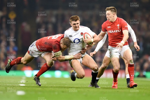 230219 - Wales v England - Guinness Six Nations - Henry Slade of England is tackled by Hadleigh Parkes of Wales 
