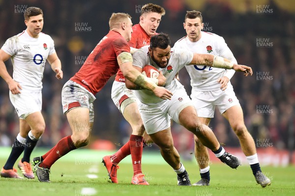 230219 - Wales v England - Guinness Six Nations - Billy Vunipola of England is tackled by Josh Adams of Wales  and Hadleigh Parkes of Wales 