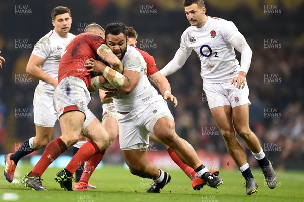 230219 - Wales v England - Guinness Six Nations - Billy Vunipola of England is tackled by Josh Adams of Wales  and Hadleigh Parkes of Wales 