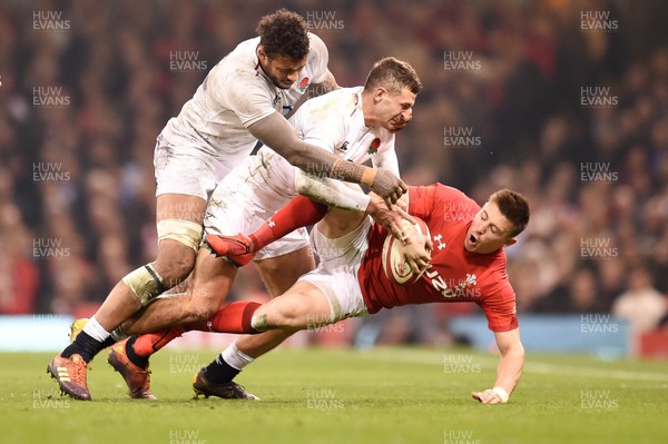 230219 - Wales v England - Guinness Six Nations - Josh Adams of Wales  is tackled by Jonny May of England  and Courtney Lawes of England 